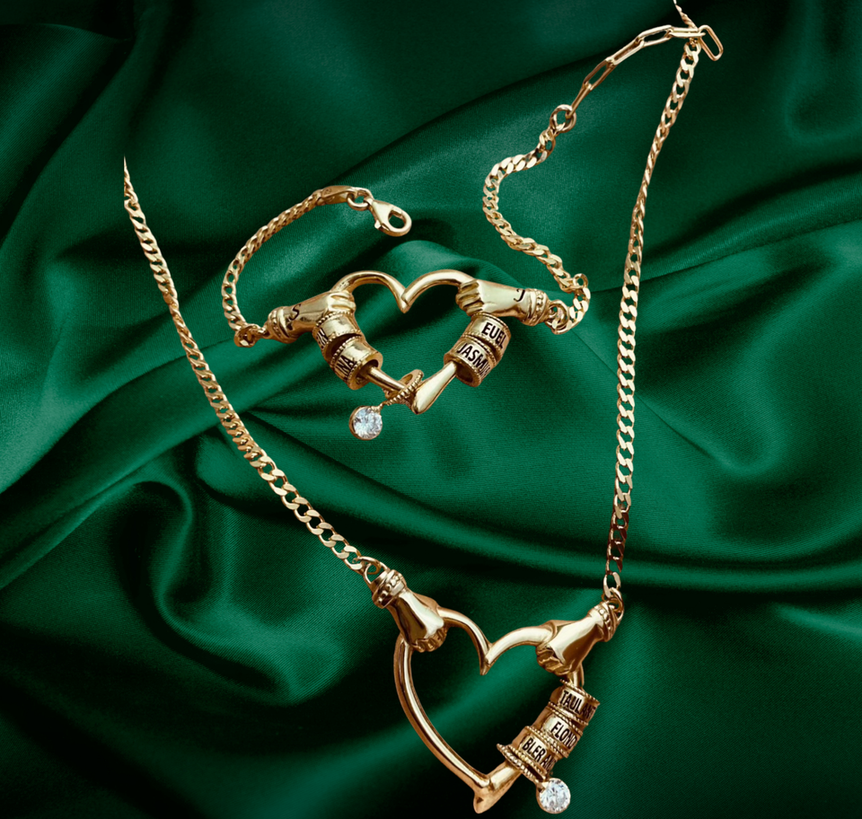 Gold heart necklace and bracelet on emerald green satin